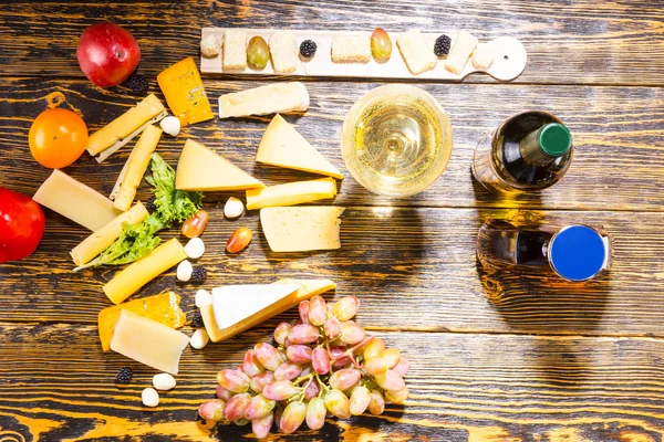Сири, фрукти та вино на дерев'яному столі — стокове фото