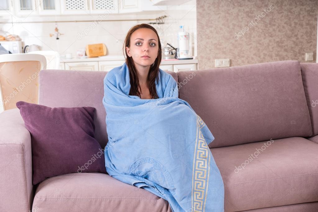 Young Woman on Sofa Wrapped in Blue Blanket