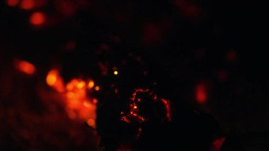 Eski bir sobada birkaç odun yanar ve birden fazla kıvılcım oluşur..