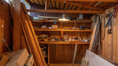 Eski bir atölyenin içinde raflar ve çeşitli parçalar vardı..