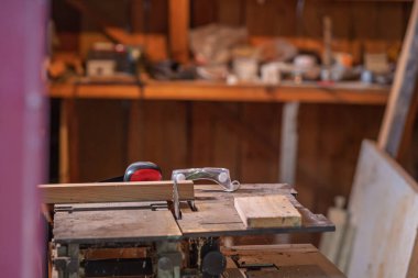 Koruyucu maskeli, ses geçirmez kulaklıklı bir bıçkıhane..