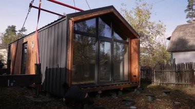 Bir işçi, modüler bir evin tabanını beton yığınlarının temelleriyle karşılaştırır..