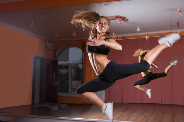 Jovem dançarina saltando no ar no estúdio de dança — Fotografia de Stock