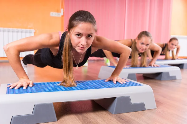 Група жінок роблять вправи на підлозі в кроці — стокове фото