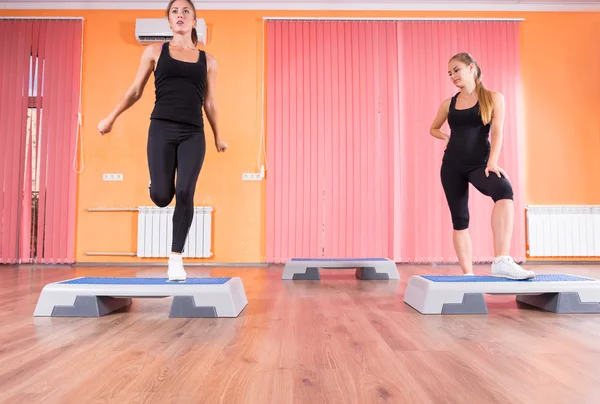 Mujeres jóvenes haciendo ejercicio juntas en clase Step — Foto de Stock