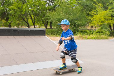Bir paten parkta oynayan genç çocuk
