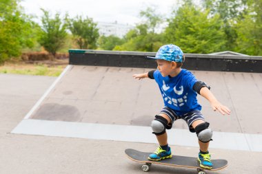 Bir kaykay üzerinde gösteriş şirin küçük çocuk
