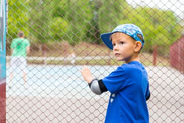 Küçük çocuk bir tenis oyunu izlerken
