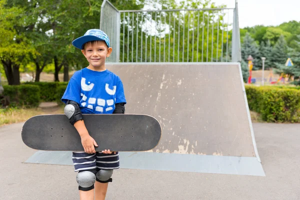 Счастливый самоуверенный мальчик со скейтбордом — стоковое фото