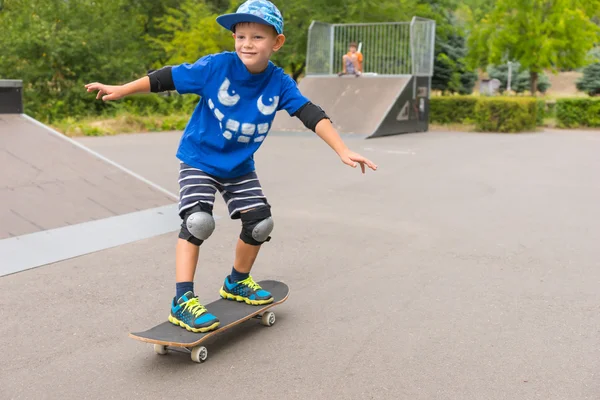 Усміхнений маленький хлопчик рветься вздовж скейтборду — стокове фото