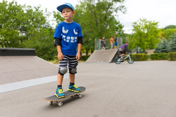 年轻的男孩站在他的滑板 — 图库照片