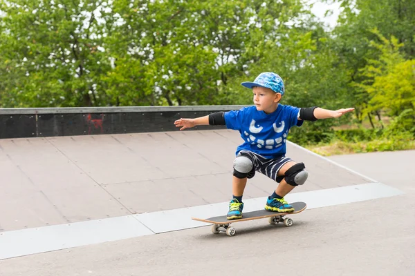 Мальчик тренируется кататься на скейтборде — стоковое фото