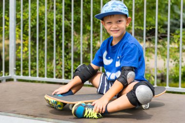 Üstüne rampa kaykay üzerinde oturan genç çocuk