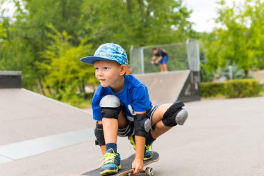 Skate Park kaykay üzerinde Crouching çocuk