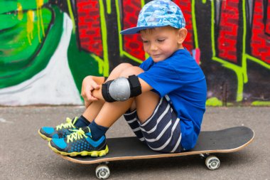 Skate Park kaykay üzerinde oturan genç çocuk