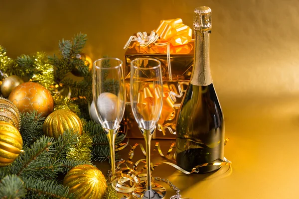 Champán festivo y regalos con decoraciones de oro — Foto de Stock