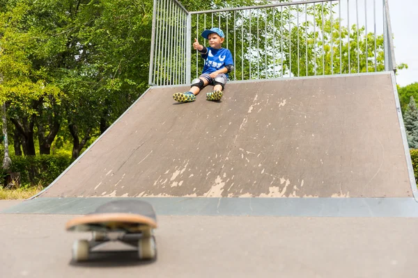 Young Boy Sitting on Top of Ramp in Skate Park — Zdjęcie stockowe