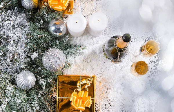 Šampaňské a dary v zasněžené vánoční zátiší — Stock fotografie