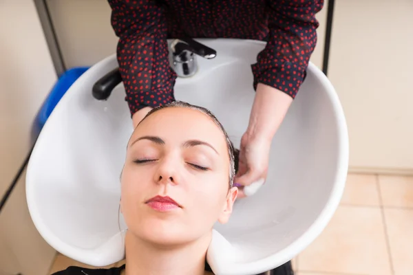 Relaxado mulher tendo cabelo lavado no salão — Fotografia de Stock