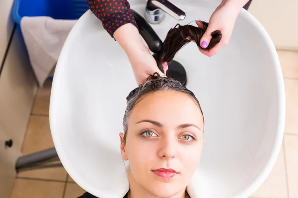 Donna che ha i capelli lavati dallo stilista nel salone — Foto Stock