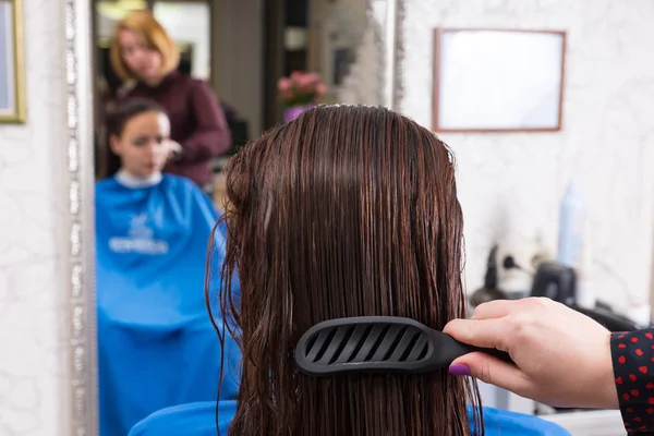 Stylist escova de cabelo do cliente morena no salão — Fotografia de Stock