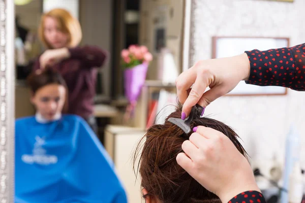 Estilista recortando el pelo de morena en el salón —  Fotos de Stock