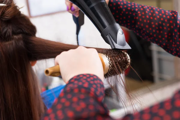 Stylista suszenia włosów brunetka klienta w salonie — Zdjęcie stockowe