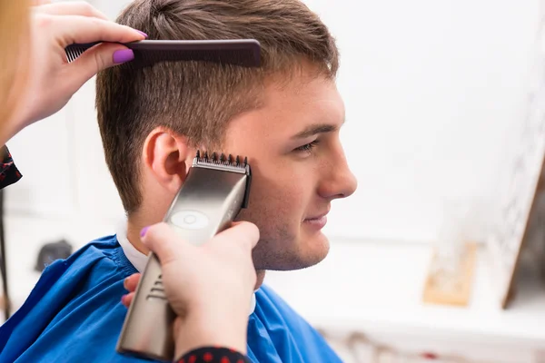 Mann lässt sich im Salon von Stylistin die Haare schneiden — Stockfoto
