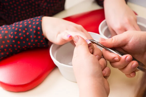 Cuticles guarnição manicure em mãos do cliente — Fotografia de Stock