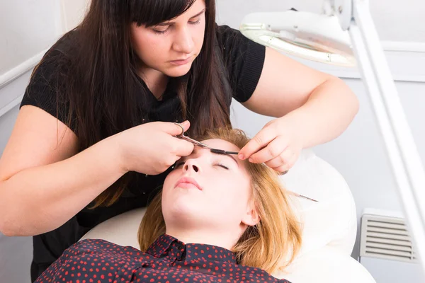 Femme ayant des sourcils taillés par esthéticienne — Photo