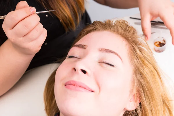 Femme souriante ayant les sourcils toilettés au spa — Photo