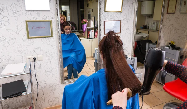 Cabelo de secagem de sopro estilista do cliente no salão — Fotografia de Stock