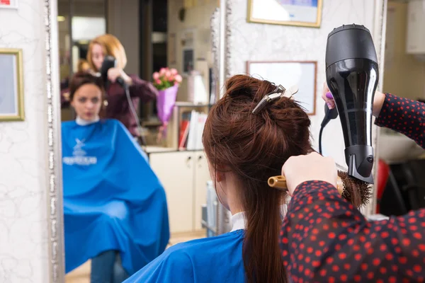 Estilista Blow Secado de cabello de cliente en el salón — Foto de Stock