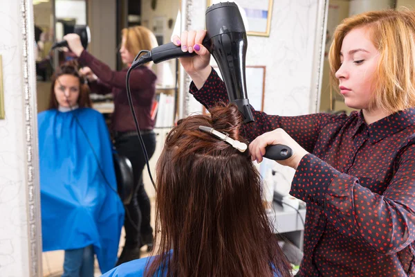 Στυλίστας χτύπημα στέγνωμα μαλλιών πελάτη στο σαλόνι — Φωτογραφία Αρχείου