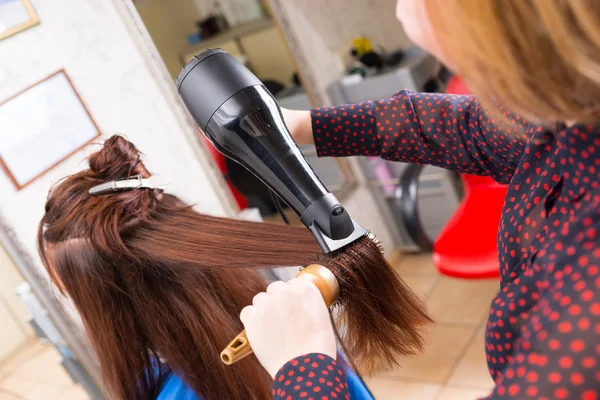 Stylist Asciugatura dei capelli del cliente bruna in salone — Foto Stock