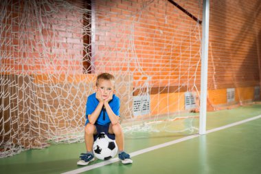 Asık suratlı genç çocuk oturma servis içinde goalposts