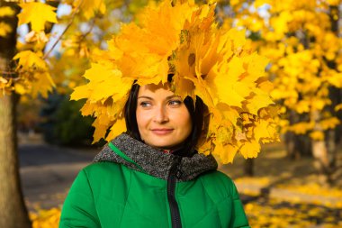 Sonbaharın bir şapka ile gülümseyen genç kadın bırakır