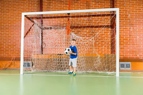 Young boy standing in soccer goalposts — Stock Photo, Image