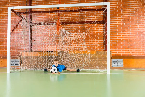 Giovane ragazzo divertirsi su un campo coperto — Foto Stock