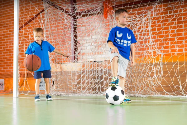 Deux jeunes garçons sur un terrain de sport intérieur — Photo