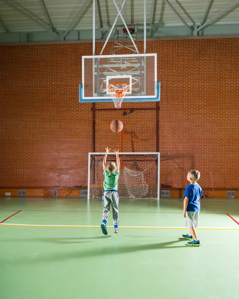 Två unga pojkar spelar basket tillsammans — Stockfoto