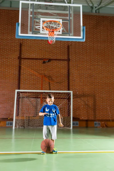 Mladý chlapec skákací basketbal — Stock fotografie