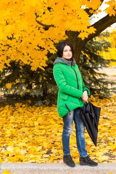 Trendy jonge vrouw lopen door een herfst park — Stockfoto