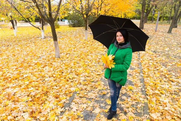 Mujer joven y bonita posando en un parque de otoño — Foto de Stock