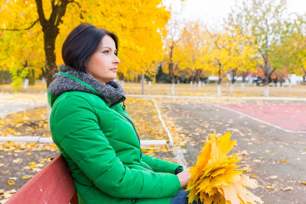 座っていた若い女性、公園のベンチで待機しています。 — ストック写真