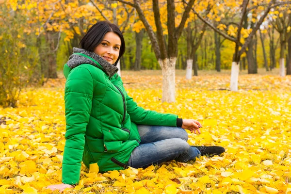 Hübsche junge Frau entspannt sich in einem herbstlichen Park — Stockfoto