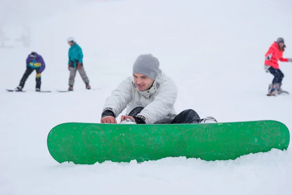 年轻人向他的滑雪板出席 — 图库照片