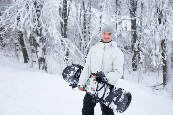 Lachende knappe jonge man met een snowboard — Stockfoto