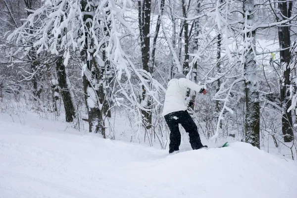 Joven snowboarder en una ladera nevada — Foto de Stock