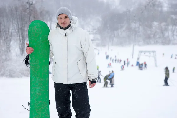 Atlético joven sosteniendo una tabla de snowboard —  Fotos de Stock